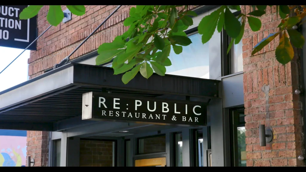 Black RE:PUBLIC RESTAURANT & BAR sign on modern brick building exterior.