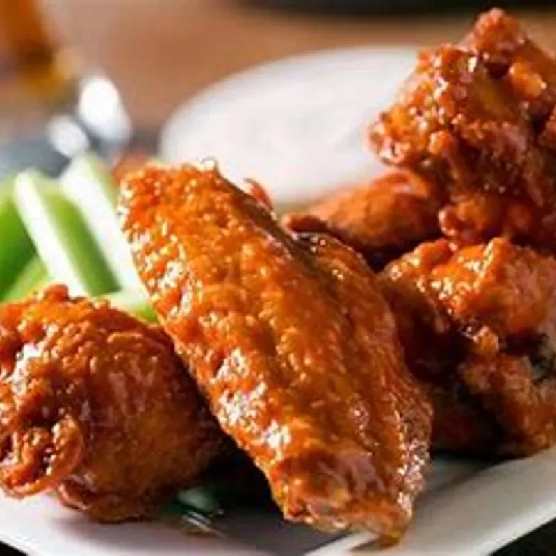 Saucy buffalo chicken wings with celery and a dipping sauce.