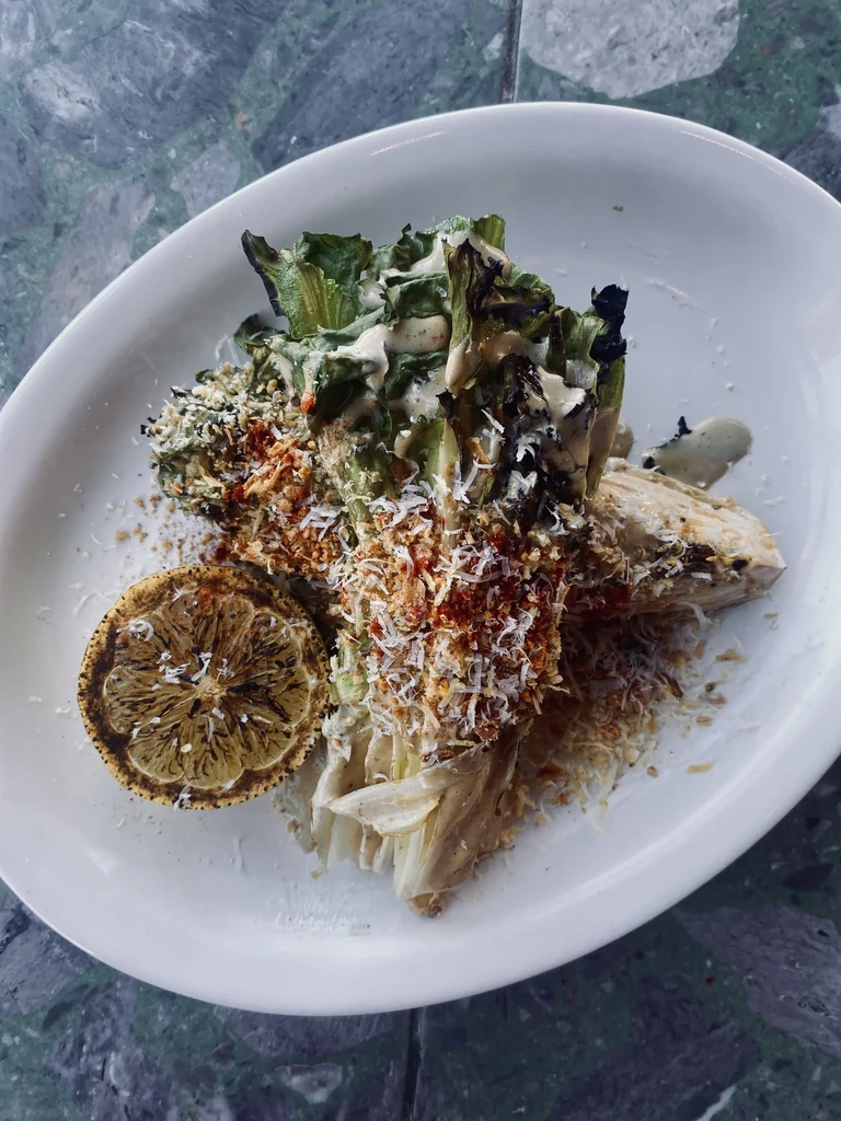 Grilled lettuce with creamy dressing, Parmesan, red spice, and charred lemon.