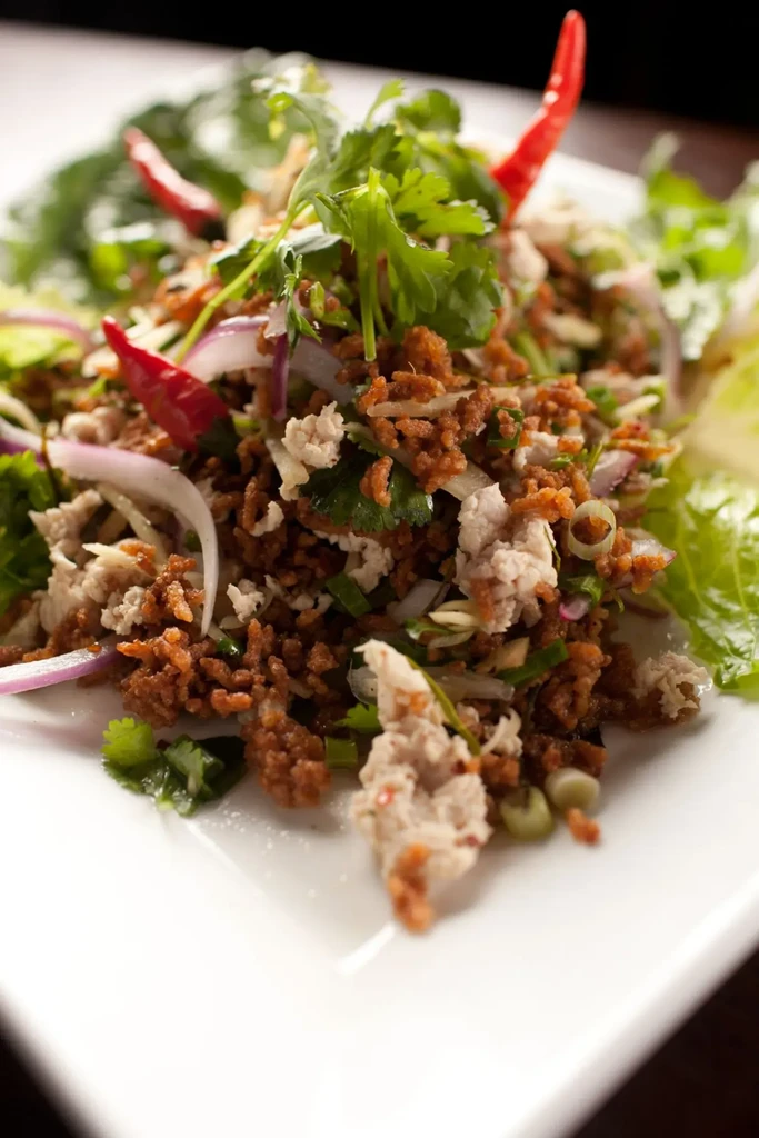Minced meat salad with fresh herbs, red chilies, and lettuce.