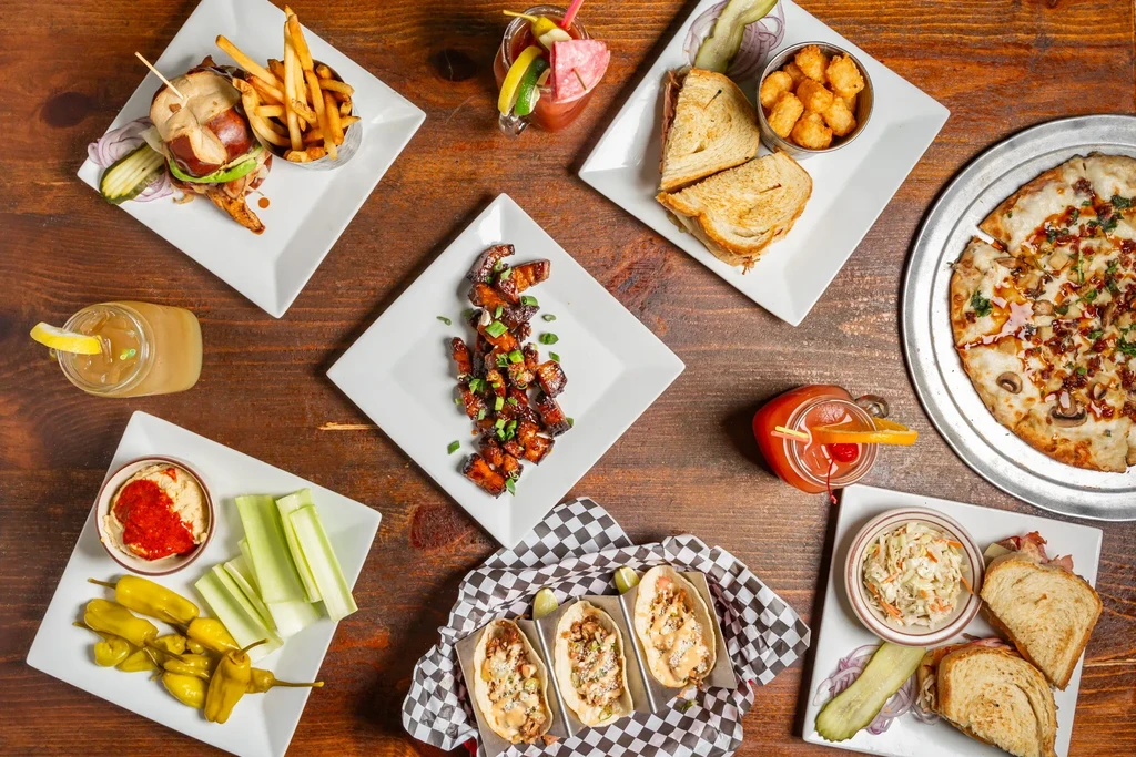 A vibrant spread of casual food and drinks on a rustic wooden table.