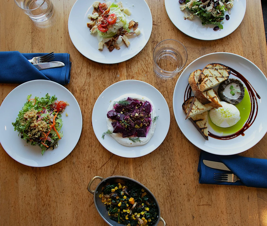 Top-down view of a wooden table with various artfully plated dishes.