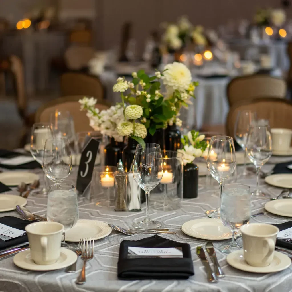 Formal dining table setting with flowers, candles, and table number 3.