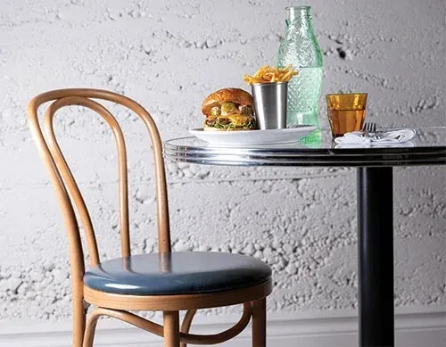 Burger, fries, water bottle, and glass on a restaurant table.