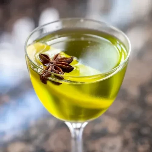Chartreuse cocktail in stemmed glass, star anise garnish.
