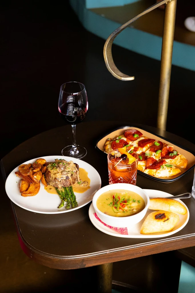 Overhead shot of a restaurant table with diverse food and drinks.