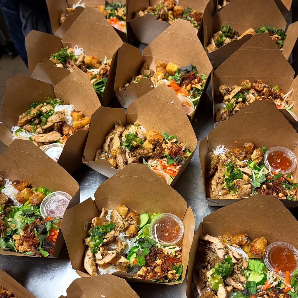 Numerous Vietnamese bún takeout meals with chicken, vegetables, and spring rolls.