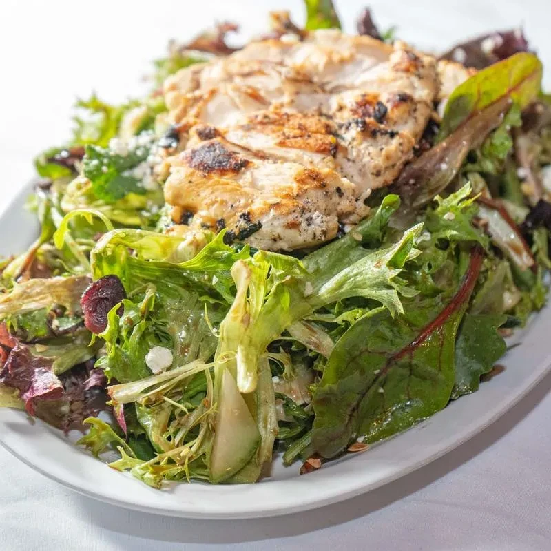 Grilled chicken salad with greens, pears, cranberries, and cheese.