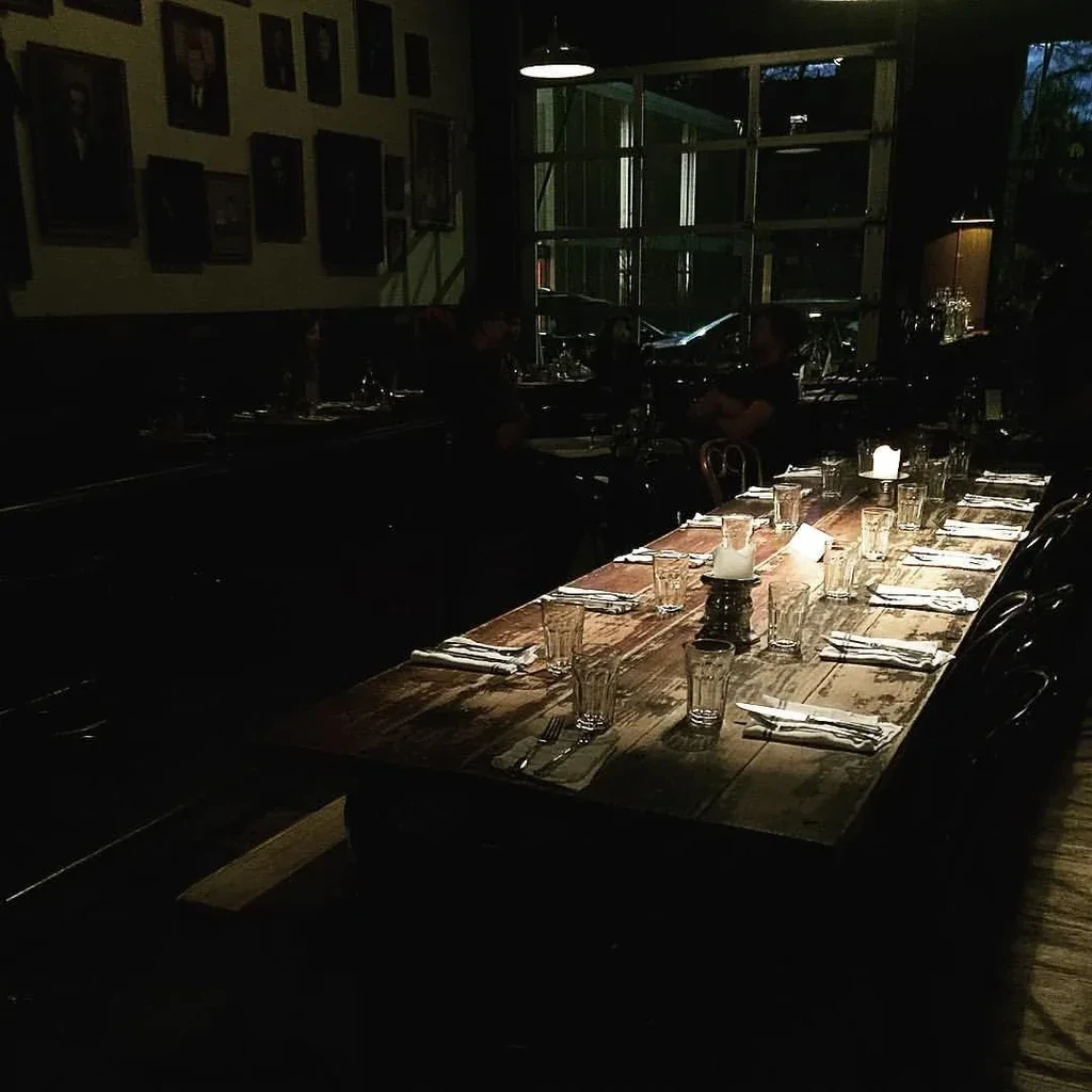 Dark, intimate restaurant: rustic wooden table set with candles.
