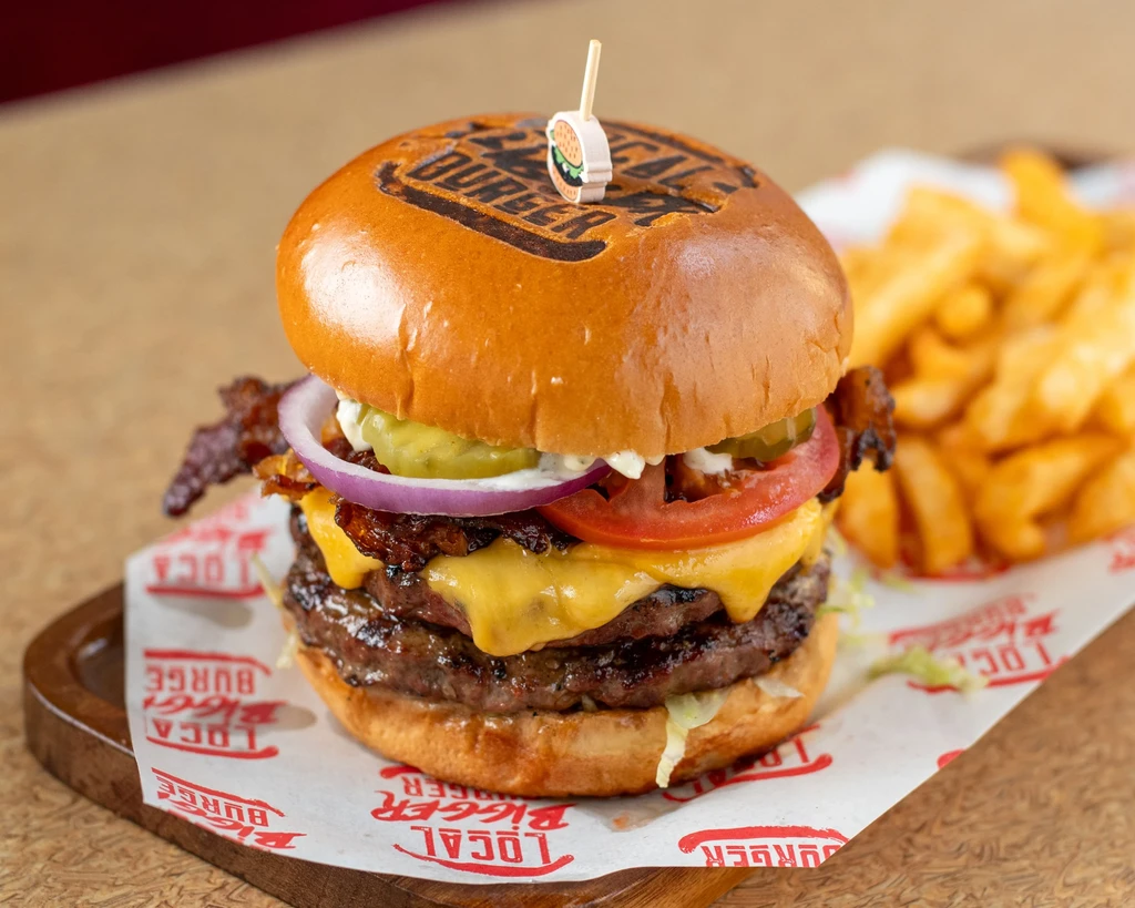 Double-patty burger with cheese, bacon, vegetables, and fries.