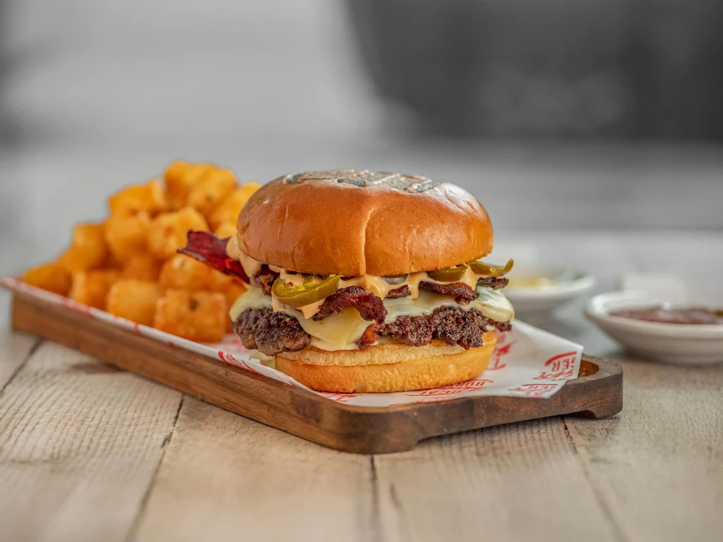 Double cheeseburger with bacon, jalapeños, and a side of tater tots.