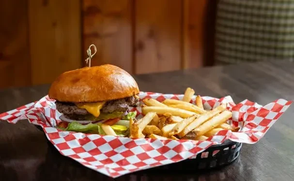 Classic burger and golden fries served in a checkered basket.