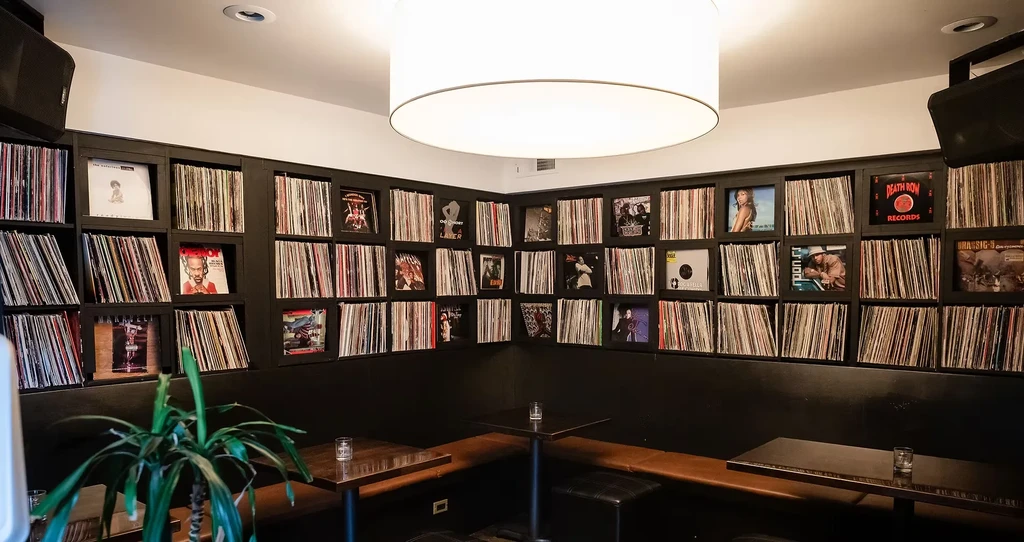 Restaurant lounge interior with a wall densely covered in vinyl records.