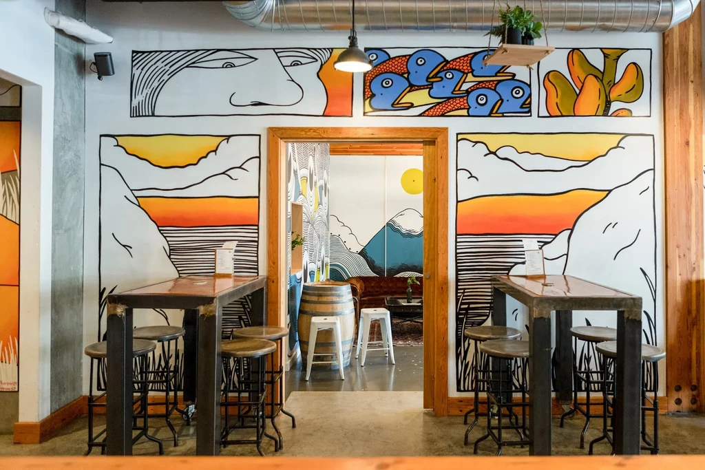 Colorful restaurant interior with diverse graphic wall murals and seating.