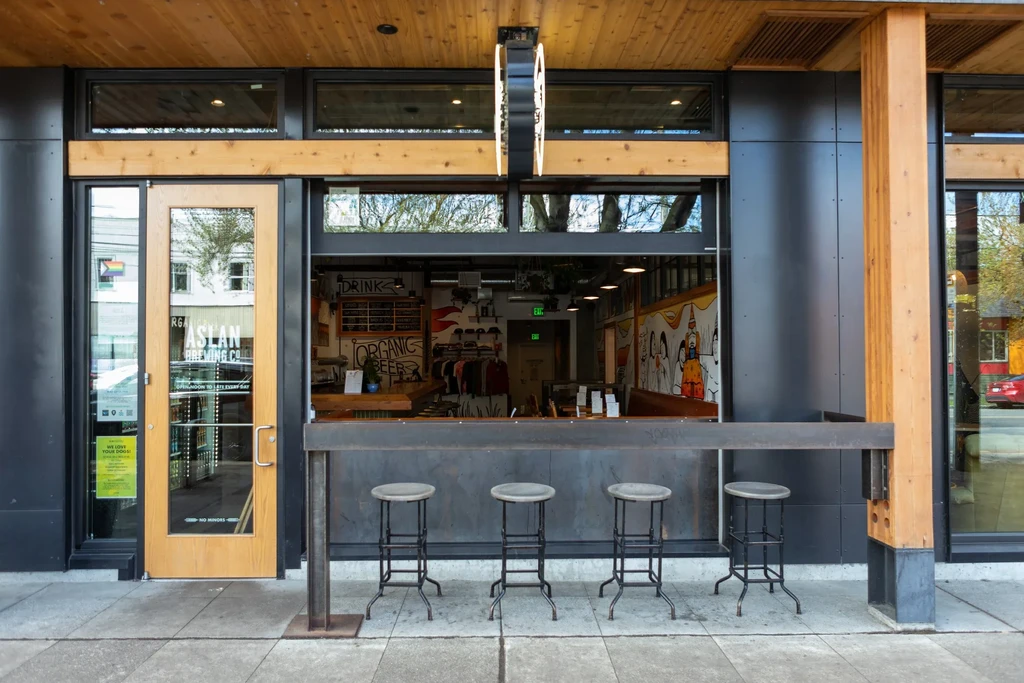 Modern Aslan Brewing Co. exterior with open-air counter and visible interior.