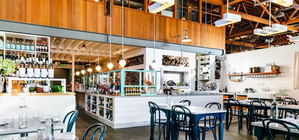 Bright, modern-rustic restaurant interior with bar, hearth, and dining.