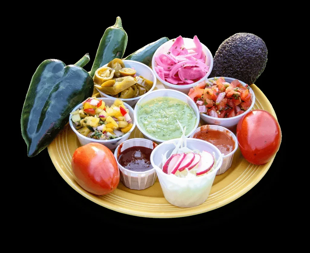 Yellow plate with cups of salsas, pickled items, and fresh vegetables.