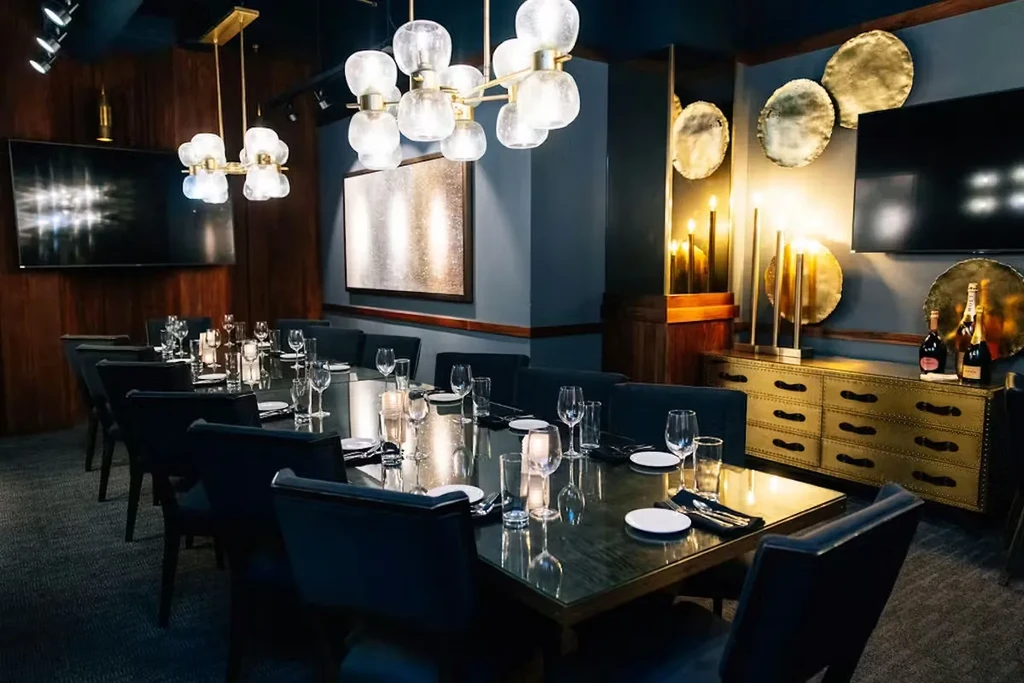 Elegant private dining room with dark, set tables and modern decor.