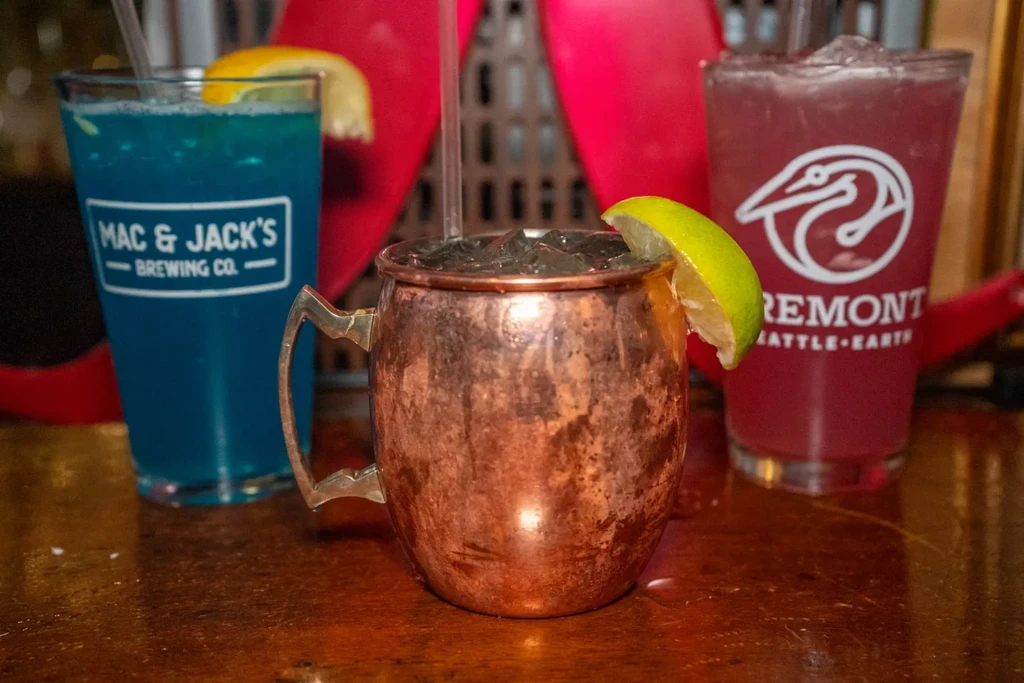 Three drinks: copper Moscow Mule, blue Mac & Jack's, purple Fremont.