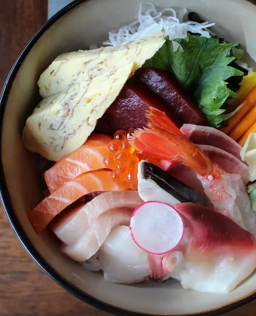Overhead close-up of a colorful Japanese chirashi bowl with various seafood.