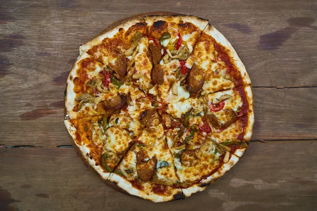 Top-down view of a pizza with cheese, peppers, mushrooms, and sausage.