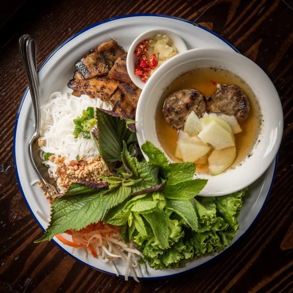 Overhead shot of vibrant Vietnamese grilled pork and noodle dish.