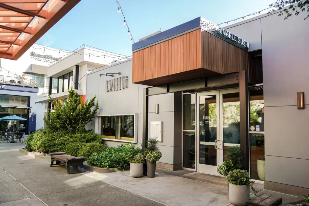 Exterior of modern Bamboo Sustainable Sushi restaurant with landscaping and string lights.