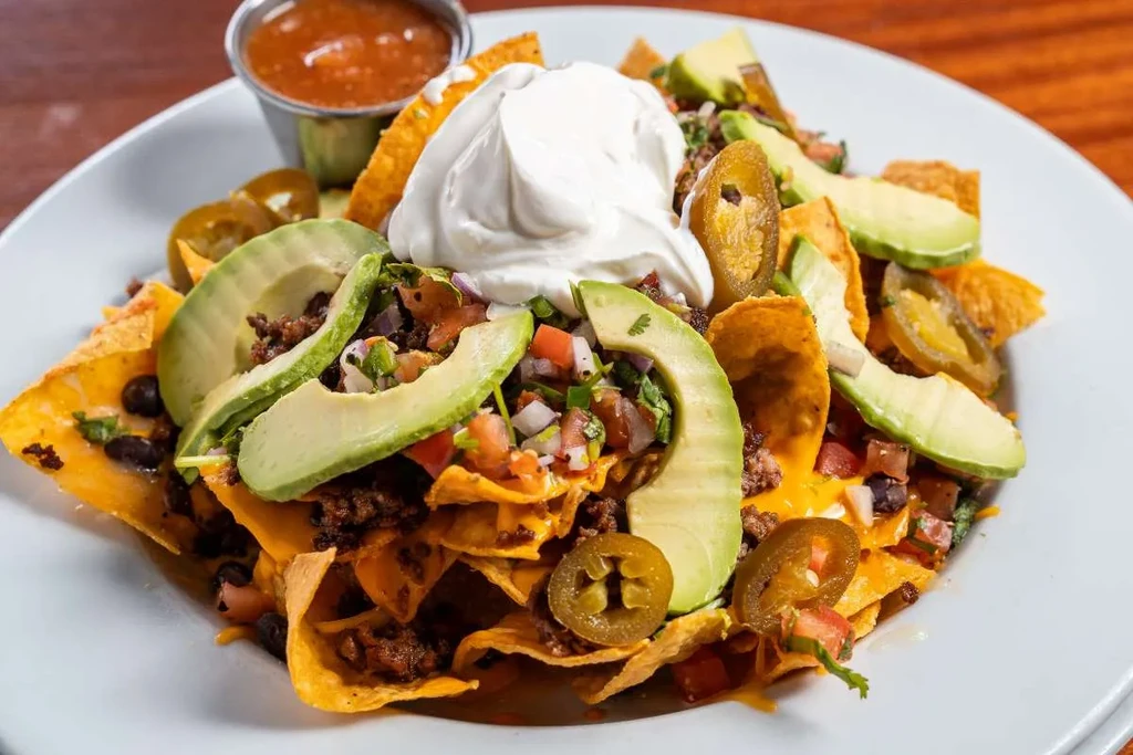 Fully loaded nachos with cheese, meat, avocado, pico de gallo, and sour cream.