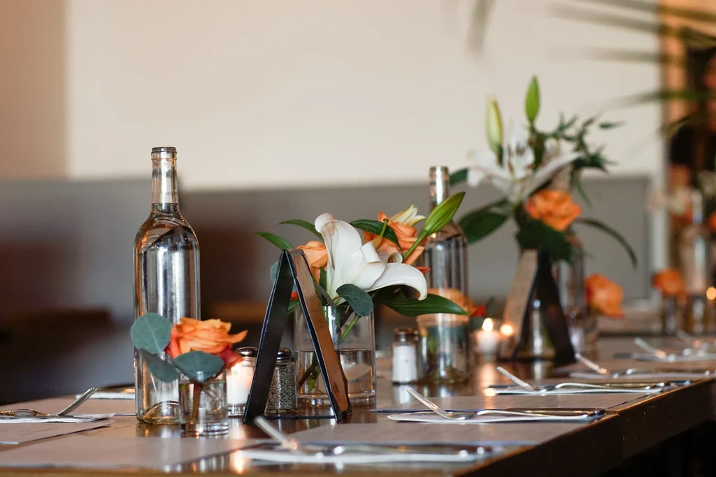 Elegant long table set with floral arrangements, place settings, and candles.