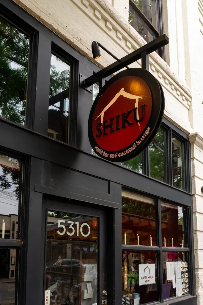 SHIKU sushi bar exterior with an illuminated circular sign.