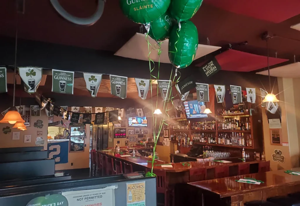 Irish pub interior with wooden bar and St. Patrick's Day decorations.