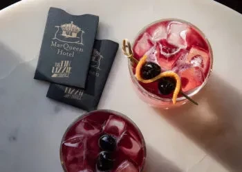 Two red cocktails with MarQueen Hotel and Lizzie Lounge branding.