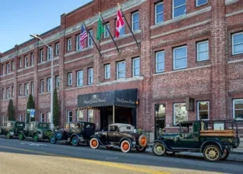Exterior of Hotel Queen Anne with vintage cars on a sunny day.