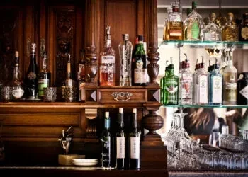 Well-stocked classic bar with numerous bottles of spirits and glassware.