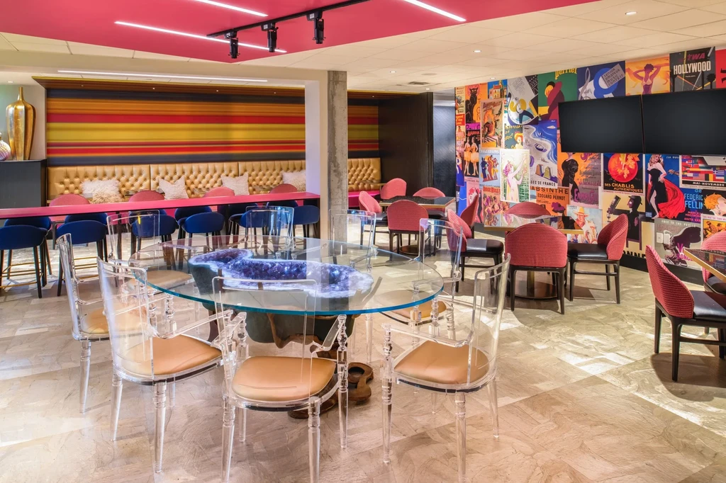Vibrant, eclectic restaurant interior with varied seating and vintage posters.