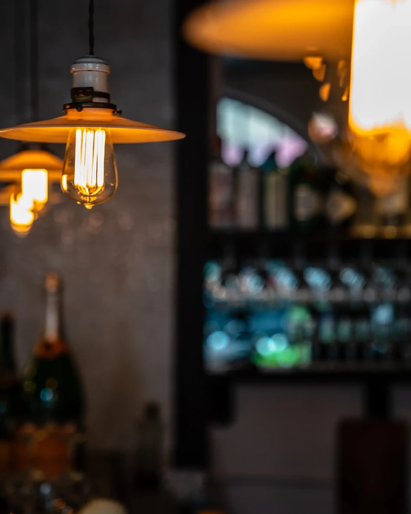 Vintage Edison bulb pendant light with a warm glow in a bar.