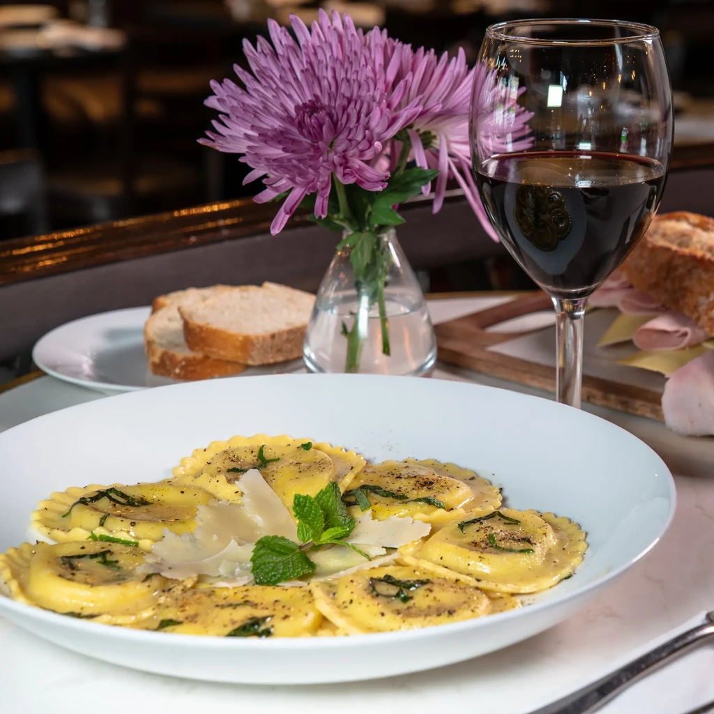 Ravioli with cheese and mint, red wine, flowers, and bread.
