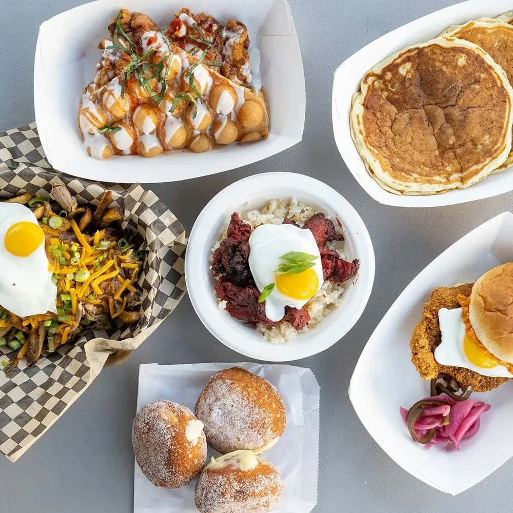Flat-lay of fried chicken, pancakes, fries, rice, and doughnuts.
