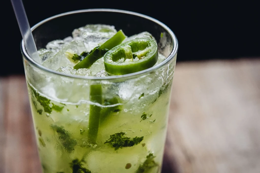 Close-up of a green cocktail with mint, chili, and crushed ice.