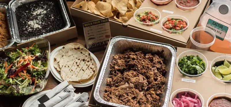 Mexican catering spread with brisket, tortillas, salsas, and margarita mix.