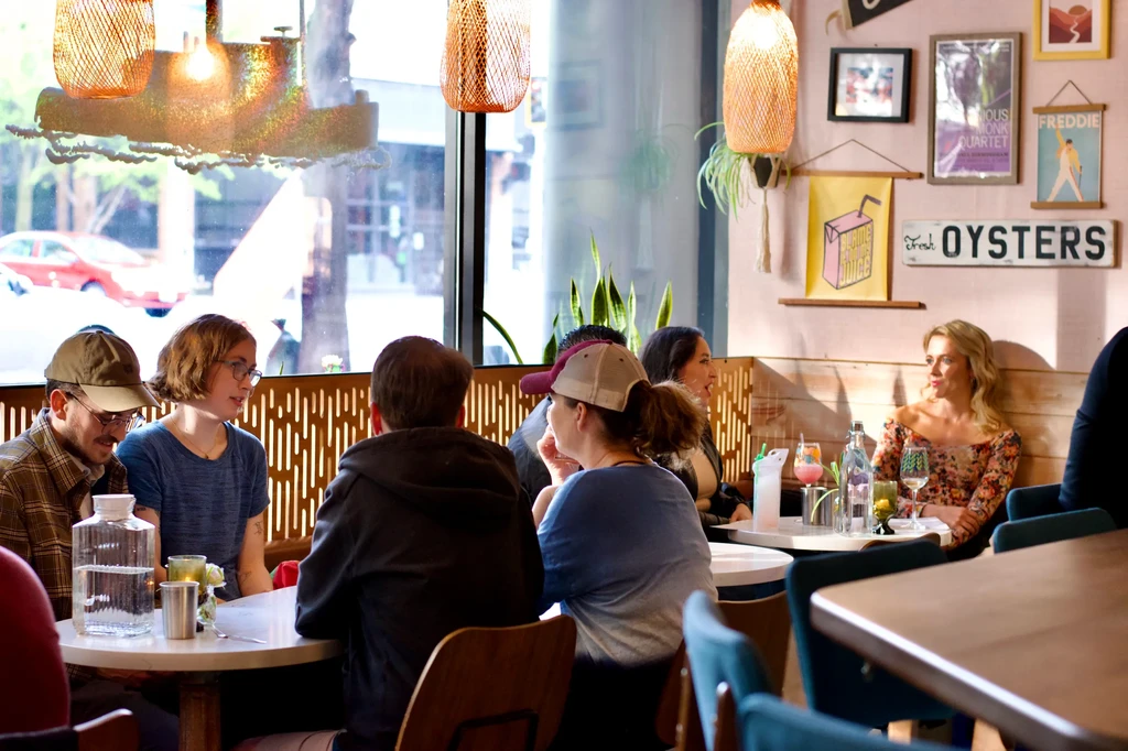 Lively restaurant interior with people dining and conversing.