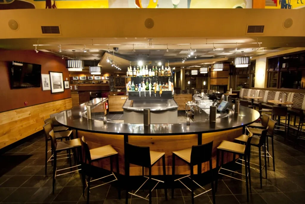 Empty modern bar and restaurant with a well-stocked semi-circular counter.
