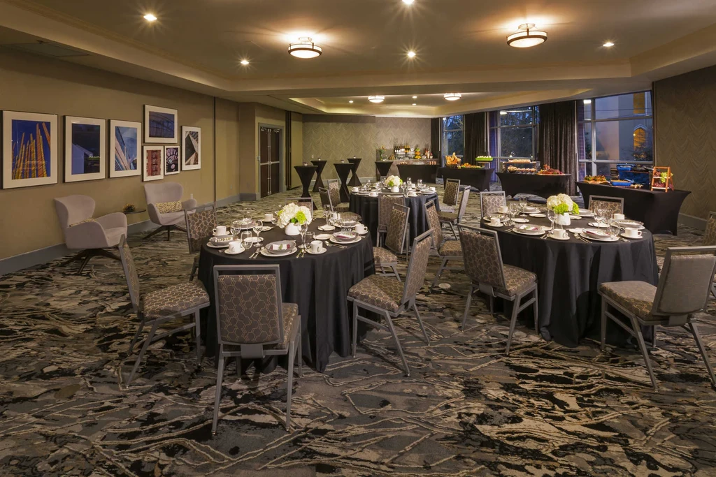 Empty, well-lit banquet hall with formal tables, buffets, and lounge.