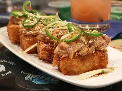 Four crispy rice squares topped with creamy protein, jalapeños, sesame seeds.