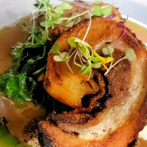 Crispy rolled meat, microgreens, leafy greens, and creamy sauce.