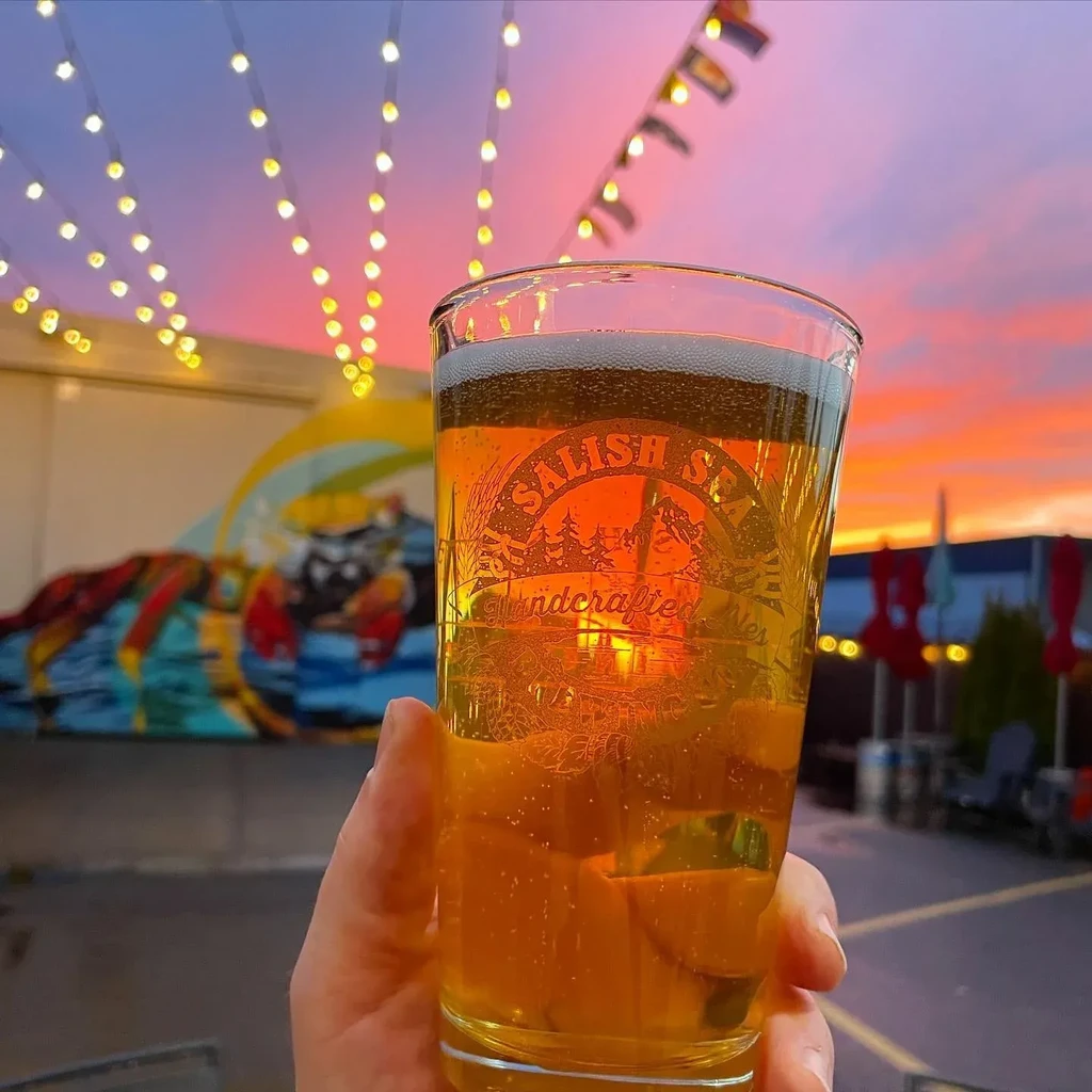 Pint of Salish Sea beer at sunset with fairy lights.