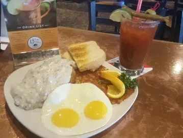 Eggs, biscuits, hash browns, toast, and a garnished Bloody Mary.