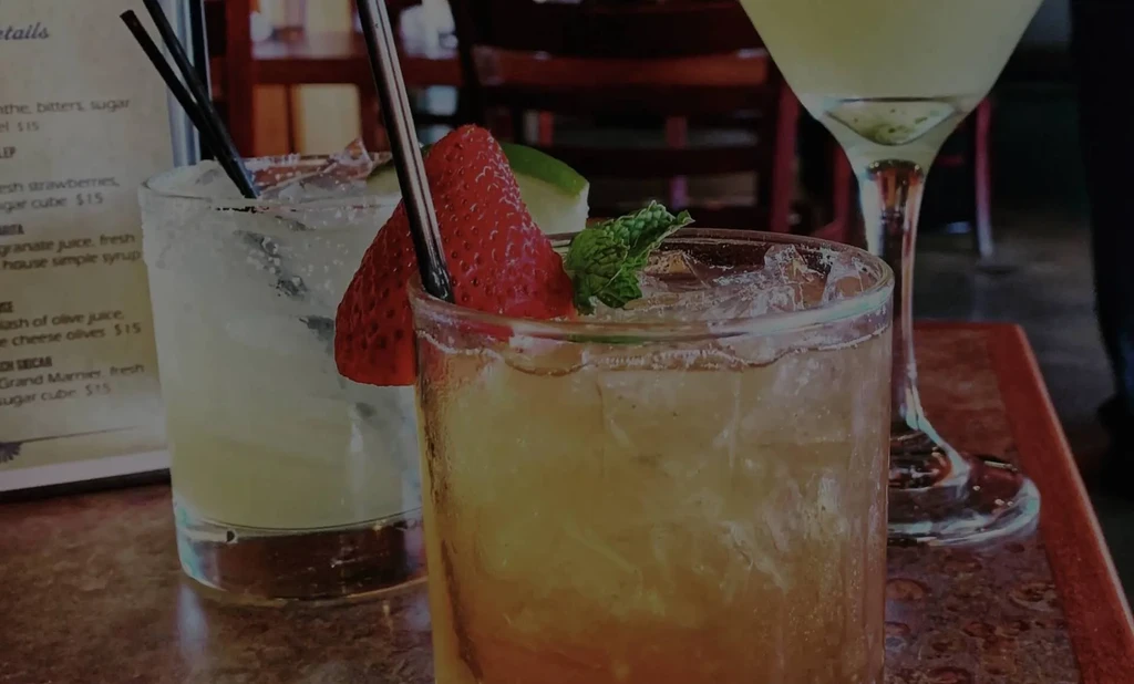 Close-up of three garnished drinks on a restaurant table.