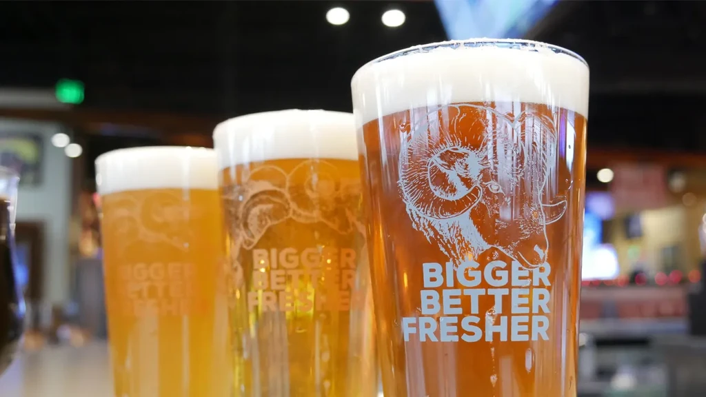 Three beers with ram's head logo and "BIGGER BETTER FRESHER" text.