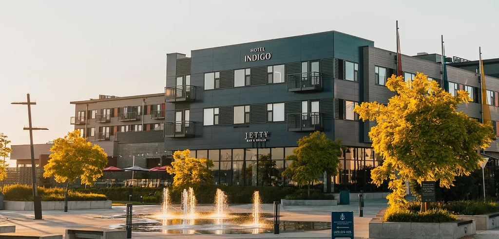 Hotel Indigo building, Jetty Bar & Grille, plaza fountain, golden light.